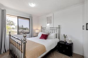 une chambre avec un lit et une grande fenêtre dans l'établissement Del Boca Vista Tuncurry, à Tuncurry