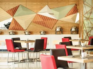 巴厘巴板巴厘巴板宜必思酒店的一家有桌椅的餐厅，椅子色彩缤纷