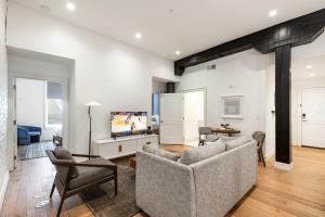 a living room with a couch and a tv at The Saddlery-Southern Set-2 Units-Walk to Broadway in Nashville
