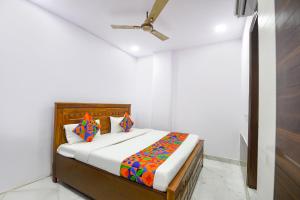 a bedroom with a bed in a white room at Fabhotel Cosy Rooms - Near Embassies, DU South Campus in New Delhi +20 photos