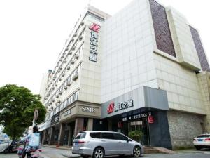 a woman riding a motorcycle in front of a building at Jinjiang Inn Nantong Tongzhou Jianshe Road in Tongzhou