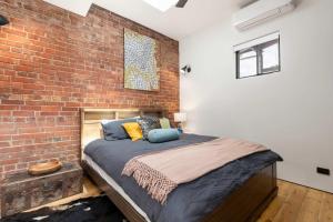 une chambre avec un mur de briques et un lit dans l'établissement The Foundry on McLaren - Urban CBD Retreat, à Adélaïde