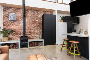 une cuisine avec un mur de briques et une cuisinière dans l'établissement The Foundry on McLaren - Urban CBD Retreat, à Adélaïde 11 autres photos