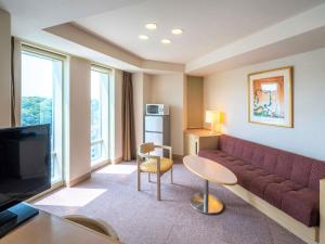 een woonkamer met een bank en een tv bij Mercure Yokosuka in Yokosuka +101 foto's