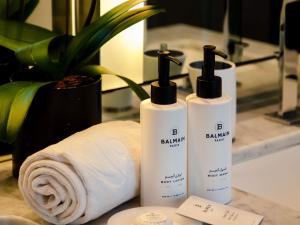 Un par de botellas de jabón sentadas junto a una toalla. en Sofitel Dubai Downtown, en Dubái 284 fotos más