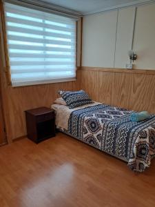 a bedroom with a bed and a window at Casa Hospedaje Costanera in Puerto Natales
