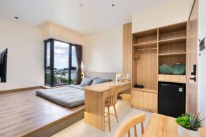 a bedroom with a bed and a desk and a table at The Rebirth Apartment Binh Chau Ho Tram in Bà Rịa