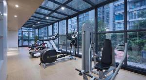 a gym with several tread machines in a building with windows at Yongzhou Chuang Fa Cheng XiaoXiangYi Hotel in Guzhuting