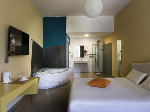 a bathroom with a bed and a tub and a sink at ibis Styles Catania Acireale in Acireale +172 photos