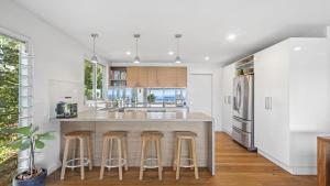 a kitchen with a large island with bar stools at Point View - 'amazing Views =& Location=' in Avoca Beach