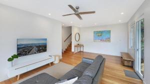 a living room with a couch and a ceiling fan at Point View - 'amazing Views =& Location=' in Avoca Beach +11 photos