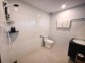 een witte badkamer met een toilet en een wastafel bij Paradise K Forest Hotel in Siem Reap