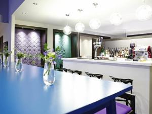 Un bar en un restaurante con una mesa y sillas. en Ibis Styles Liverpool Centre Dale Street - Cavern Quarter, en Liverpool