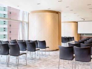 a conference room with black chairs and a screen at Ibis Hong Kong Central & Sheung Wan in Hong Kong