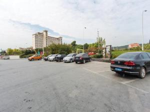 uma fila de carros estacionados num parque de estacionamento em Jinjiang Inn Suzhou Shihu International Education Park em Suzhou