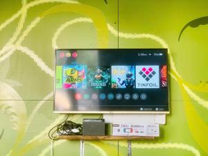 a tv on a wall with games on it at The Little Leaf Hostel - Restaurant & Rooftop Bar CatBa in Cat Ba