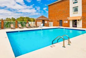 Una gran piscina con sillas y un edificio. en The Windstar Hotel - Emerald Isle, Swansboro, en Cedar Point
