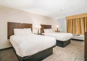 ein Hotelzimmer mit zwei Betten und einem Fenster in der Unterkunft The Windstar Hotel - Emerald Isle, Swansboro in Cedar Point