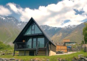 卡兹贝吉Misty Valley的山上的房子，背景是群山