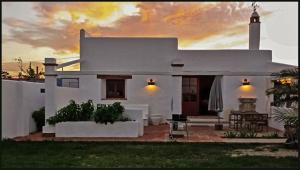 a white house with a sunset in the background at Casa Entre Armonías in Zahara de los Atunes