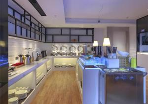 a large kitchen with white counters and appliances at Echarm Hotel Nanning Dongge Macun Metro Station in Nanning