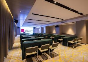 a room with green tables and chairs and a screen at Echarm Hotel Nanning Dongge Macun Metro Station in Nanning