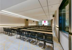 a lecture hall with rows of tables and chairs at Echarm Hotel Nanning Wuxiang Headquarters Base in Nanning