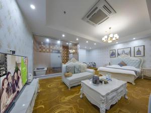 a large living room with two beds and a tv at Shell Hotel Taixing Huangqiao Town Dinghui Road in Hengxiang