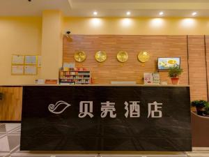 a counter in a store with writing on the wall at Shell Hotel Taixing Huangqiao Town Dinghui Road in Hengxiang