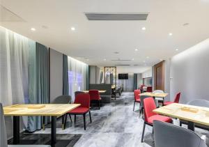 a restaurant with wooden tables and red chairs at Borrman Hotel Guigang Pingnan Donghu in Pingnan