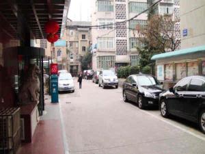 eine Stadtstraße mit Autos auf dem Bürgersteig in der Unterkunft Jinjiang Inn Hefei Sanxiaokou Lujiang Road in Hefei