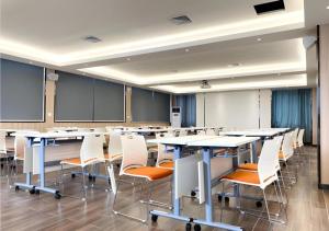 a classroom with tables and chairs in a room at Borrman Hotel Guigang Pingnan Donghu in Pingnan