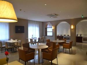 Un restaurante con mesas y sillas y una cocina. en Jinjiang Inn Select Jinggangshan Scenic Spot Bus Station, en Jinggangshan