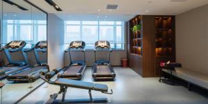 a gym with a row of treadmills in a room at E-Cheng Hotel Shenyang North Railway Station in Shenyang