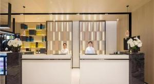 two women in a salon with mirrors in a room at Echarm Hotel Changsha Xiangya Fushan in Changsha