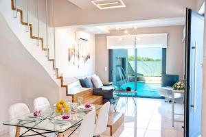 a dining room and living room with a glass table and white chairs at Ferienhaus Für 12 Personen In Kavallos, Kreta West Kreta in Kávallos +32 photos