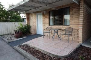 a patio with chairs and a table in front of a house at SunPalms Motel in Rockhampton