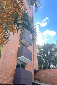 Un edificio de ladrillo con balcones a los lados. en Poblado ApartaSuite familiar cerca club campestre, en Medellín
