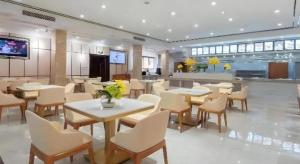 a dining room with tables and chairs in a building at GreenTree Alliance Hotel Chengdu Dujiangyan Sands Bird's Nest in Dujiangyan