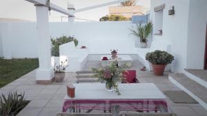 a patio with a table and some potted plants at Casa Entre Armonías in Zahara de los Atunes