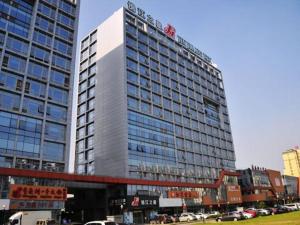 a large building in a city with cars at Jinjiang Inn Suzhou Railway Station Huqiu in Suzhou