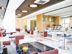 a restaurant with white chairs and tables and a bar at Jinjiang Inn Suzhou Railway Station Huqiu in Suzhou