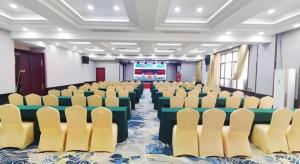 a conference room with chairs and tables and a screen at Borrman Hotel Liuzhou High-Speed Railway Station in Liuzhou