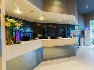 a lobby with a counter with a vase of flowers at Jinjiang Inn Wuhan Jiangtan Nanjing Road Science Museum in Wuhan