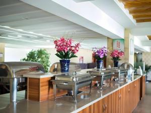 a row of sinks with vases of flowers on them at Green Tree Inn Tibet Lhasa Zhaji Temple in Lhasa
