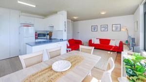 a kitchen and living room with a table and chairs at Seaview 7 - Prime Position Beachside Holiday in Avoca Beach +6 photos