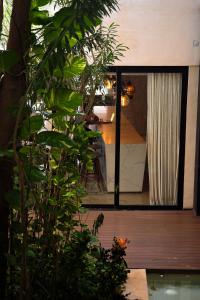 a house with a large glass window with a view of a room at Hotel Travertino in Mérida