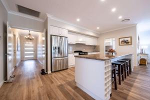 una cucina con mobili bianchi e un piano di lavoro di Lakeside on Southlakes - Family Entertainer a Dubbo Altre 31 foto