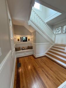 eine Treppe in einem Haus mit weißen Wänden und Holzböden in der Unterkunft Charming Historic Charlotte Home in Charlotte
