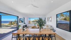 a dining room with a table and chairs and the ocean at Omaroo House - Views Over Copa Beach in Copacabana